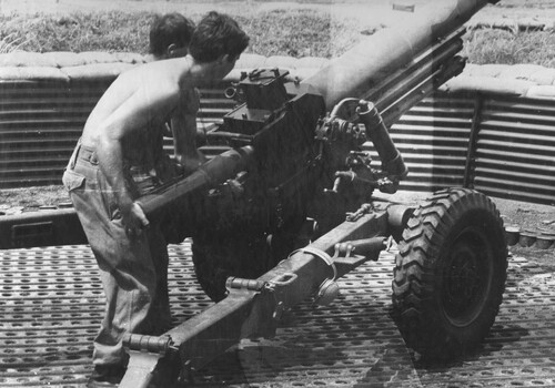 A photograph of diggers at 103 Battery load a 105mm Italian Pack Howitzer during a fire mission from the 1st ATF Base, Nui Dat.