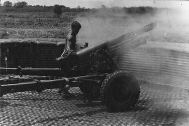 A photograph of a digger at 103 Battery Phuoc Tuy Province, as he fires a 105mm Italian Pack Howitzer. 