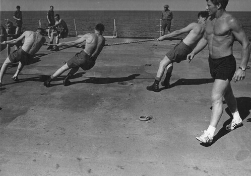 A photograph of diggers from the 9th Battalion, Royal Australian Regiment excercising with the Army physical training instructor Sgt Rob Fulton. 