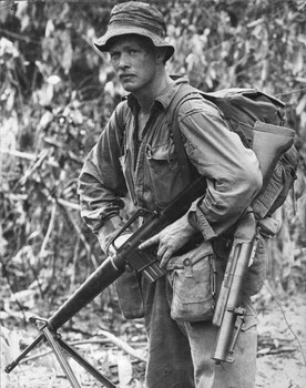 A photograph of Private G.L. Condon, 7 Platoon, Charlie Coy 4th Battalion/New Zealand stopping for a short rest while patrolling in Bien Hoa Province. 