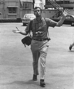 A black and white photograph of Denis Gibbons, as he waves to the camera at 1 ATF Base.