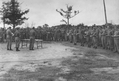 A photograph of assembled Diggers at 1 ATF Base, Nui Dat, Phuoc attending an open air multi - denominational church service conducted by Padres. 