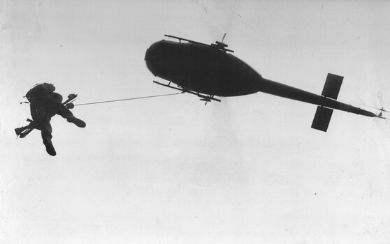 A photograph of a Huey 'slick' aircraft from the RAAF's 9 Squadron, winching a wounded Digger from 8 RAR during 'Operation North West' .