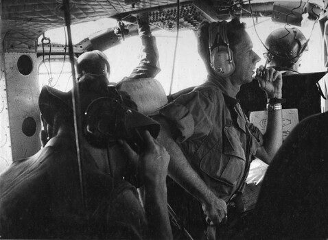 A photograph of an American advisor to the Vietnamese Army with an Australian Navy radio operator on board a 135th Assault Helicopter. 