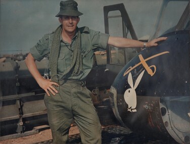 A photograph of Denis Gibbons, standing beside a Huey Gunship from the 334th Armed Helicopter Battalion stationed at Bien Hoa. 