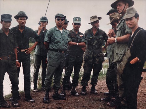 A photograph of three members of AATTV discussing operational requirements with the senior Vietnamese Army Colonel at Pleiku, South Vietnam. 