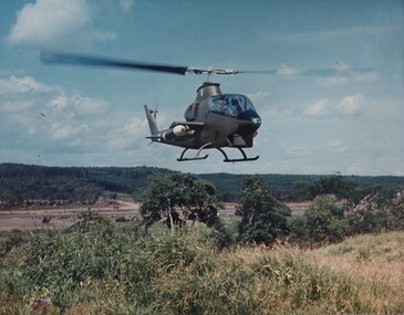 A photograph of a Bell AH-1G Huey Cobra from the 1st Platoon 334th Armed Helicopter, lands at the base area of the SAS Regiment. 