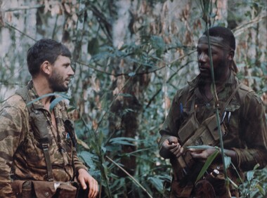 A photograph of a member of the AATTV discussing operational problems with one of his American counterparts. 