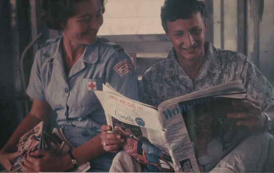 A photograph of Pte Peter Lapsco and Red Cross Nurse Janice Webb sharing something highly amusing in Woman's Day during her hospital rounds. 