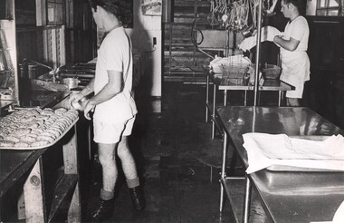 A photograph of two cooks from the Royal Australian Catering Corps preparing meals for staff and patients at the 1st Australian Field Hospital. 