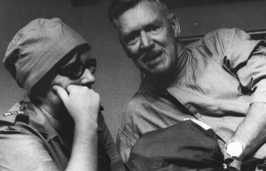 A photograph of Nursing Sister, Capt Ann Hall. She is in deep conversation with a patient at the 1st Australian Field Hospital, Vung Tau. 