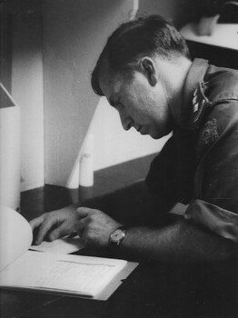 An officer at the 1st Australian Field Hospital Vung Tau is engrossed in the task of filling out his reports and other paperwork