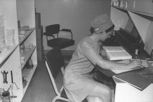 A photograph taken at the 1st Australian Field Hospital, Vung Tau, South Vietnam. Sister Capt Fay Lewis catches up on paper work.