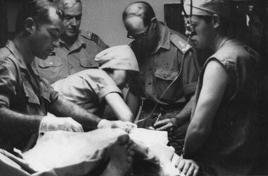 A photograph at the 1st Australian Field Hospital, Vung Tau, The triage team  are resusitating a wouded digger. 