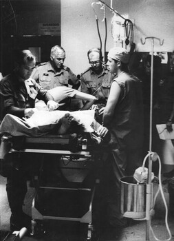 A photograph of a triage team at the 1st Australian Field Hospital, American surgeon Wg Audio, Theatre Nurse Capt June Minchow.