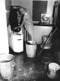 A photograph taken at the 1st Australian Field Hospital. Medic Cpl Alex Berry sorts, prepares and loads the washing machine with operating theatre laundry. 