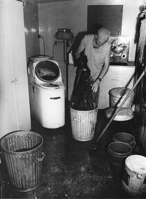 A photograph of the laundry at the 1st Australian Field Hospital. Cpl Alex Berry cleans and prepares theatre laundry materials for washing and sterilization.