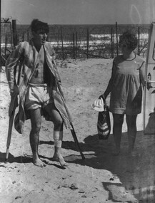 A photograph of Carmel O'Shea, assisting Pte Dave Henderson, a wounded forward scout from 8 RAR, return to the Red Cross vehicle. 