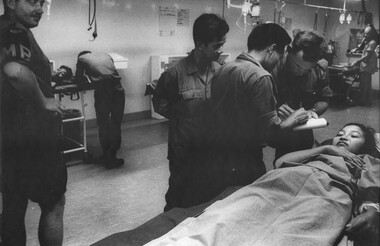 A photograph in the triage of the 1st Australian Field Hospital,a female VietCong prisoner whilst an Australian MP looks on.