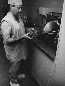 A photograph of a medic at the 1st Australian Field Hospital, Vung Tau, placing instruments to be sterilized in an autoclave following surgery. 