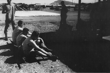 A photo of 1st Australian Field Hospital Medic Tony Green and his fellow medics rest, waiting for the arrival the Dustoff medivac helicopter. 