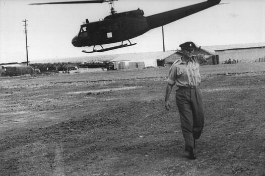 A photo of CO Lt Col Mike Naughton, at the 1st Australian Field Hospital,arriving at the 'Vampire' pad on an American Dustoff helicopter. 