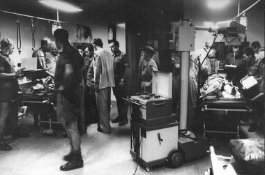 A photo of triage at the 1st Australian Field Hospital. Maj Nell Espie watches intently as the team work on a female VietCong prisoner. 