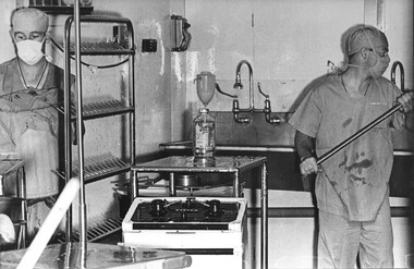 A photo at the 1st Australian Field Hospital, Medic Tony Thomas is assisted by another medic as they clean and sterilize the operating theatre. 