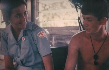 A photograph of Red Cross nurse Jean Debelle with Pte Mike Iredale during her hospital rounds at the 8 Field Ambulance Hospital, Vung Tau. 