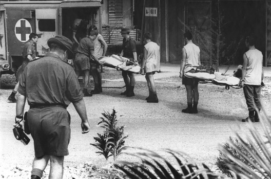 A photo of 1st Australian Field Hospital Medics Richard Sneigowski, Ron Gillespie and Ray Yates load patients for the journey Vung Tau Military Airfield. 