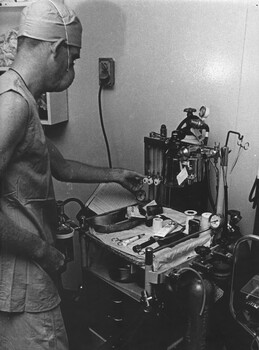 A photograph of Corporal (Chuck) Berry, adjusts the anaesthesia machine in the operating theatre at 1st Australian Field Hospital, Vung Tau. 