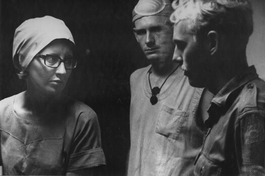 A photograph theatre sister Capt June Minchow and Medic Corporal Alex (Chuck) Berry discuss an operating theatre problem with another corporal Medic. 