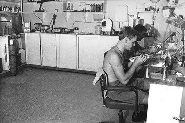 A photograph of two Dental Technicians work on the construction of sets of false teeth in their well equiped Dental Laboratory. 