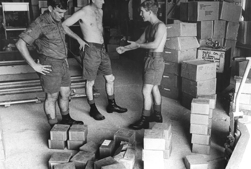 A photograph at 1st Australian Field Hospital, Digger in the Quartermaster's store appears to be making a point to one of his colleagues. 