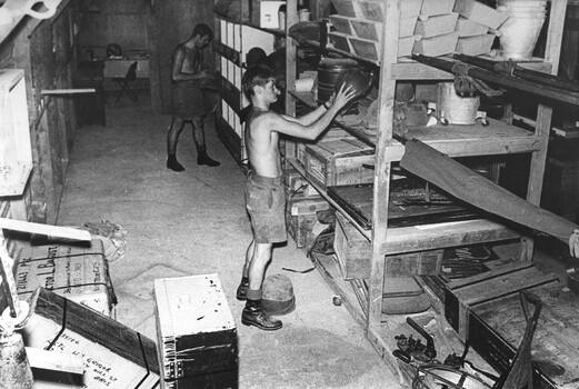 A photograph of Stores staff in the Quartermasters Store at 1st Australian Field Hospital check and stack stores. 