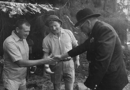 A photograph at the 1st Australian Field Hospital. Medic in a bowler hat welcoming guests to a party at the unit in April 1970. 