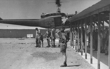 A photo of medics at 1st Australian Field Hospital turn their heads to escape rotor wash from an American "Dustoff" medivac evacuation helicopter.