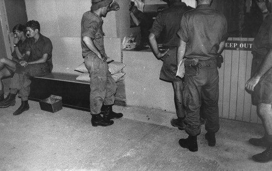 A photograph of Nursing Sister Captain Shirley Southwell answers the telephone as she mans the regimental aid post the 1st Australian Field Hospital. 