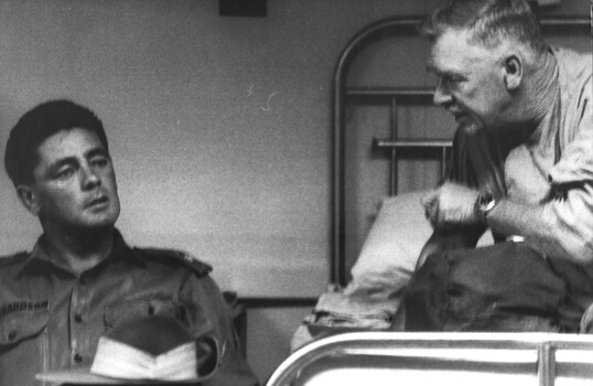 A photo of a patient talking  to a member of the AATTV visiting him at the 1st Australian Field Hospital before being medivaced. 