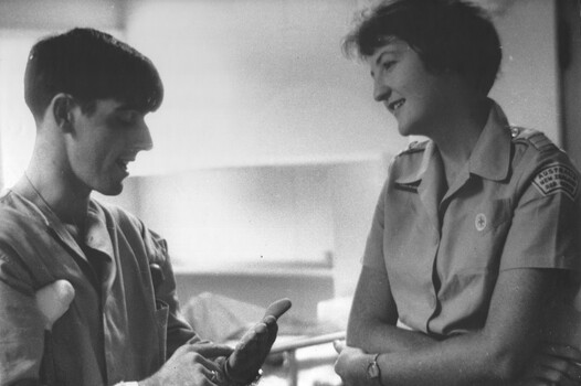 A photograph at 1st Australian Field Hospital, Red Cross girl Carol Eacott chats with Private Dave Henderson a wounded forward scout of 8 RAR. 