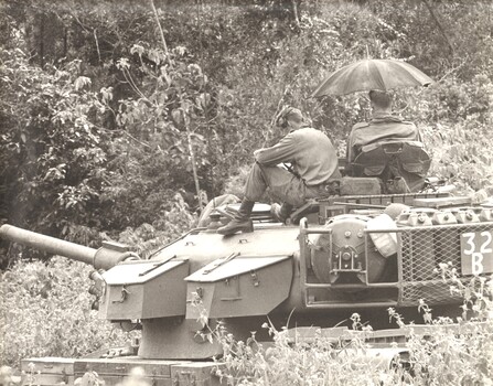 A black and white photograph of a Centurian tank of 1st Armoured Regt is stopped during a lull in fighting awaiting orders to move. 