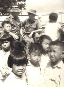 A photograph of Children mill about as Lt Phil Hills OC 1st Australian Task Force Health Officer, Field Hygiene Unit, Nui Dat. 