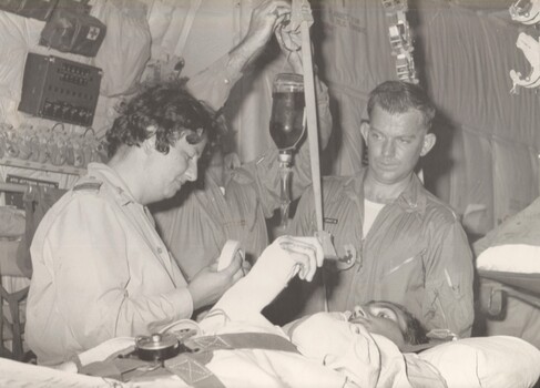 A photograph at Vung Tau, F.O. 'Irish' Connelly a RAAF Nurse with a patient to be flown from Vietnam on board a RAAF flight