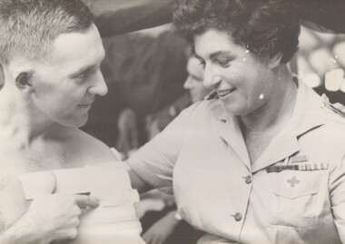 A photograph taken at Vung Tau of Bandsman/Stretcher Bearer Pte Graeme Davis, 6 RAR talking to Australian Red Cross worker Miss Hilda Zimmer.