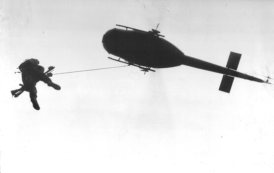 A photograph of a Huey of the RAAF's No.9 Sqn, winches a wounded Digger from 8 RAR during Operation North West of the ATF.