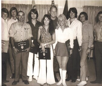A black and white photograph of Entertainesr receiving a presentation from the OC HQ.