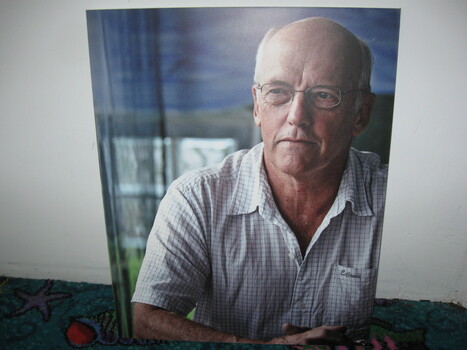 Upper body colour image of balding man with wire-rimmed glasses looking to his right.