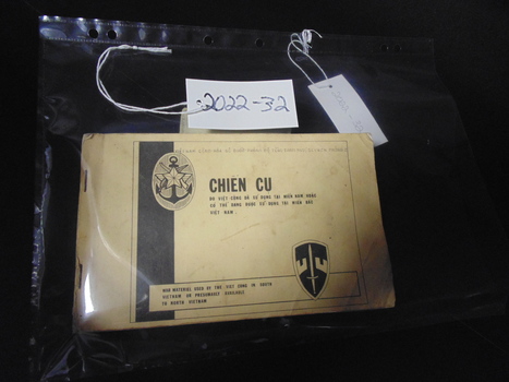 Small booklet with two staples on left hand side with black writing.