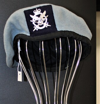 A blue felt beret with black binding and a silver 161 Reconnaissance flight  badge located on the front.  