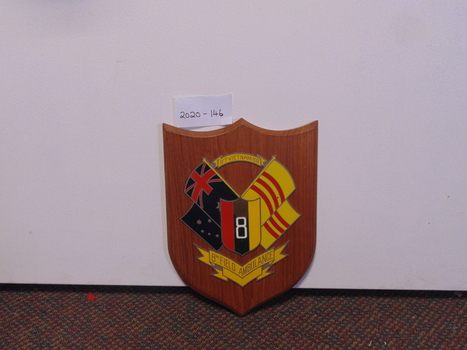A wooden plaque bearing the emblem of 8th Field Ambulance Corp,  1967 - 1968 in Vietnam. 